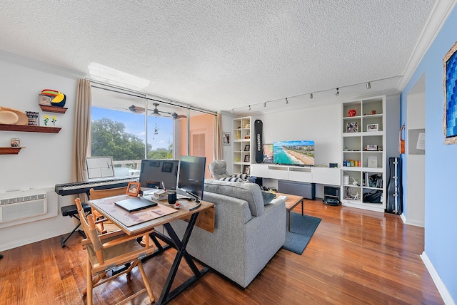 living room with an AC wall unit, a textured ceiling, track lighting, and hardwood / wood-style floors