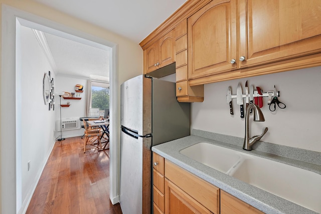 kitchen with stainless steel fridge, a wall mounted AC, sink, and wood-type flooring