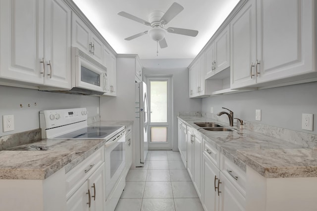 kitchen featuring ceiling fan, light tile patterned flooring, sink, white appliances, and white cabinetry