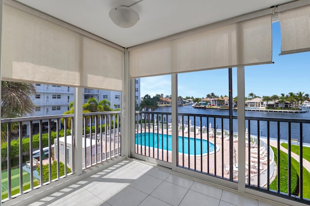 balcony featuring a water view and ceiling fan