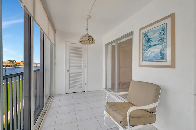 sunroom featuring a water view