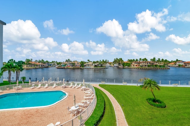 view of swimming pool with a water view and a yard