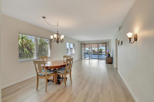 dining area featuring light wood-type flooring and an inviting chandelier