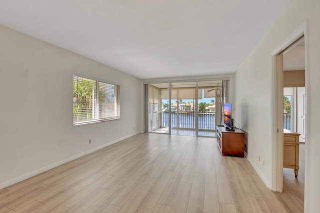 unfurnished room featuring light wood-type flooring and plenty of natural light