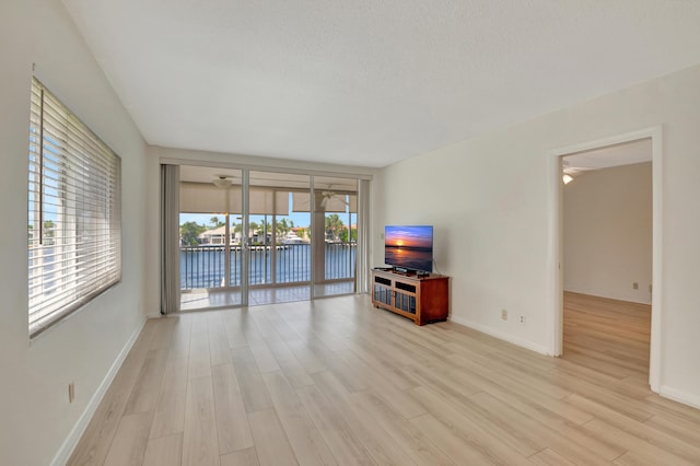 unfurnished living room featuring light hardwood / wood-style floors and a textured ceiling