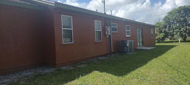 view of property exterior with a lawn and central AC