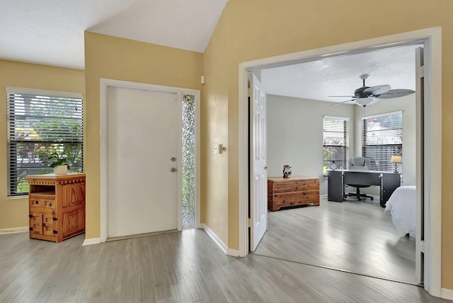 foyer entrance featuring a wealth of natural light, light hardwood / wood-style flooring, ceiling fan, and lofted ceiling