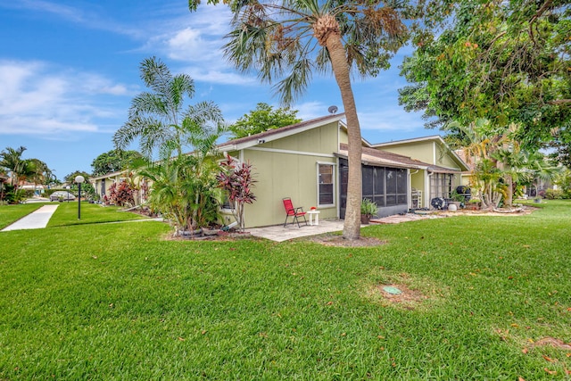 back of property with a sunroom and a yard