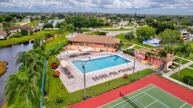 view of pool featuring a lawn, a water view, and a patio