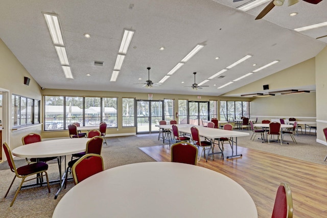 carpeted dining room featuring ceiling fan and vaulted ceiling