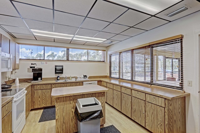 kitchen featuring sink, wood counters, a drop ceiling, light hardwood / wood-style flooring, and white appliances