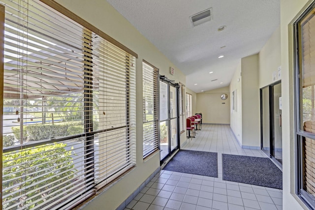 interior space featuring light tile patterned floors and a textured ceiling