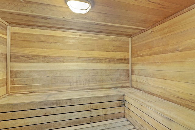 view of sauna with wood ceiling and wooden walls