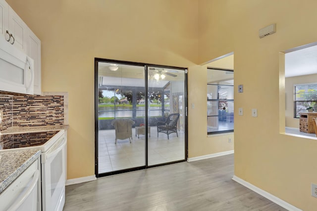 doorway featuring ceiling fan and light hardwood / wood-style floors