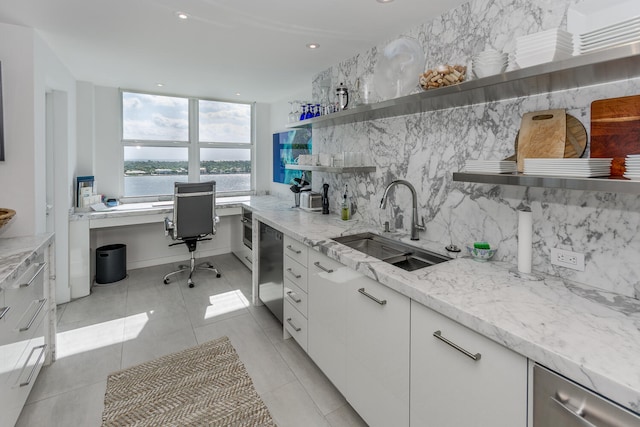 interior space featuring sink, floor to ceiling windows, and a water view