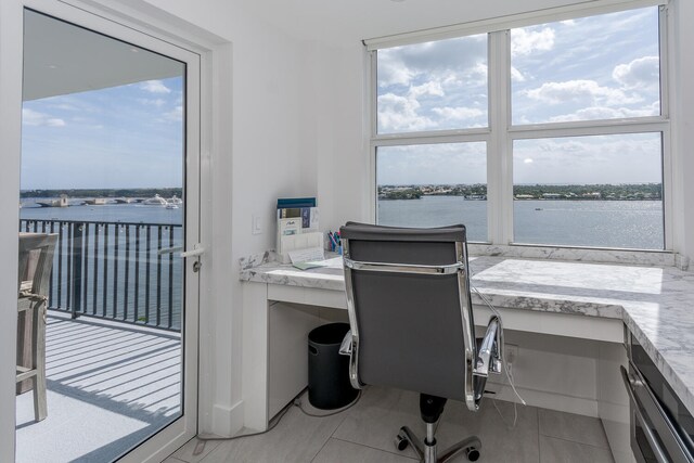 tiled home office with a water view and a healthy amount of sunlight