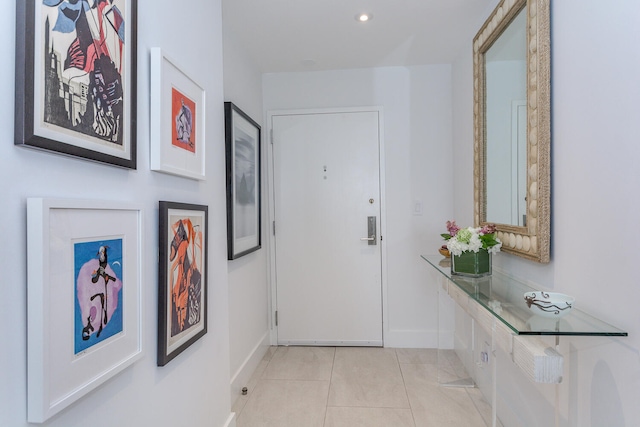 hall featuring recessed lighting, baseboards, and light tile patterned floors