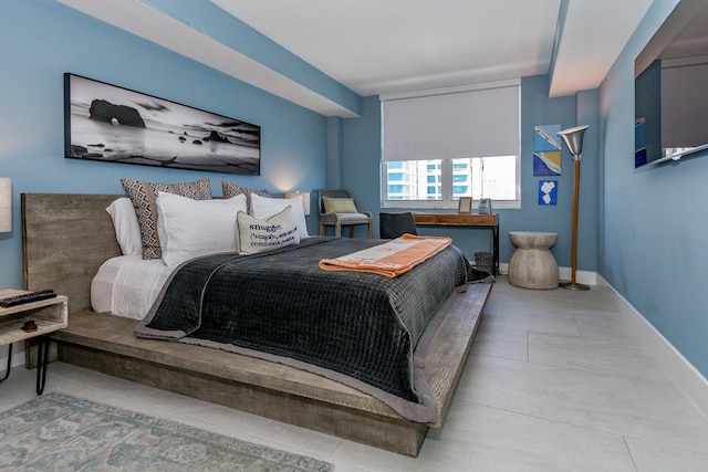 bedroom with baseboards and light tile patterned floors