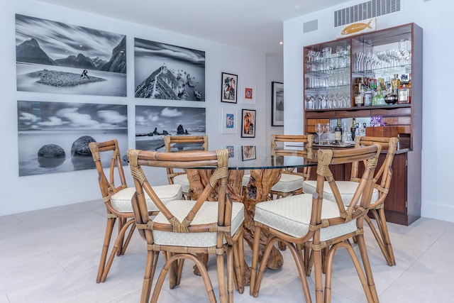 dining area with a bar, baseboards, and visible vents