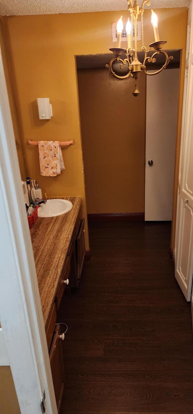 bathroom featuring a textured ceiling, vanity, a chandelier, and wood-type flooring