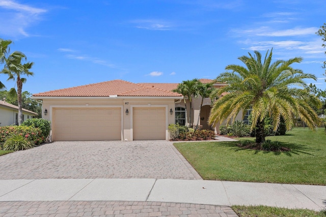 view of front facade with a garage, a tiled roof, decorative driveway, stucco siding, and a front yard