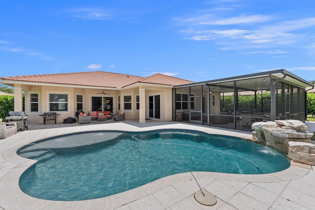 view of pool with a patio, an outdoor hangout area, pool water feature, a sunroom, and a grill