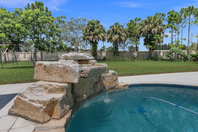 view of pool with pool water feature and a yard