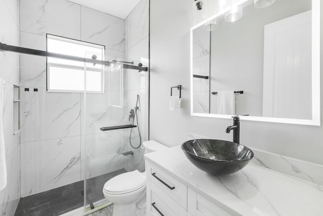 bathroom featuring a shower with shower door, toilet, and vanity