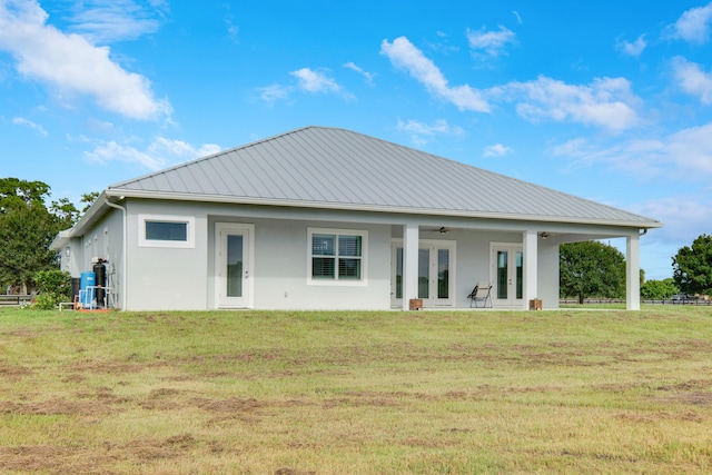 back of house featuring a yard and ceiling fan