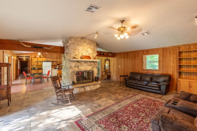 living room featuring lofted ceiling, ceiling fan, wooden walls, and a stone fireplace