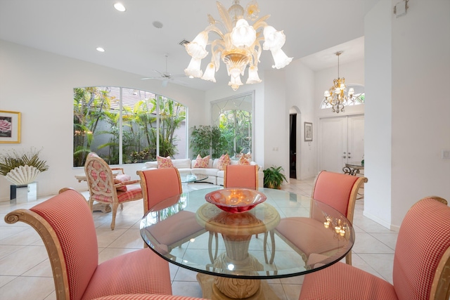 dining space with ceiling fan with notable chandelier and light tile patterned floors