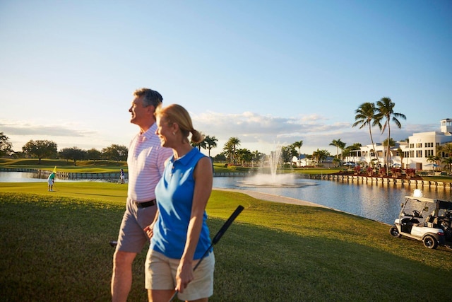 surrounding community featuring a water view and a lawn