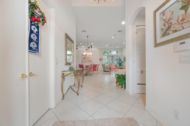 hall featuring a chandelier and light tile patterned flooring