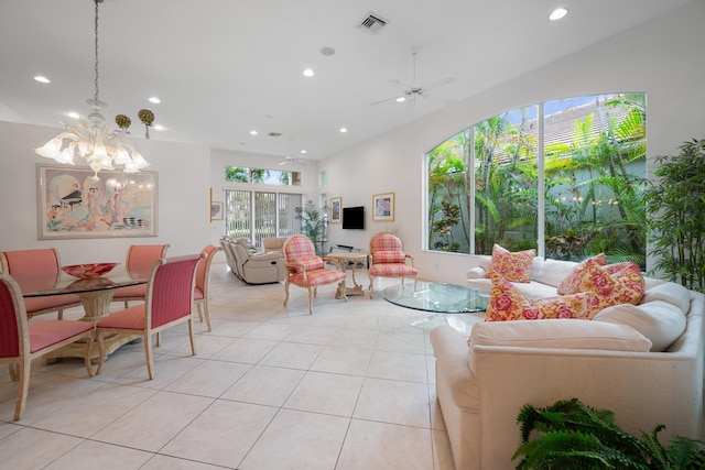 living room with light tile patterned flooring, ceiling fan with notable chandelier, and plenty of natural light