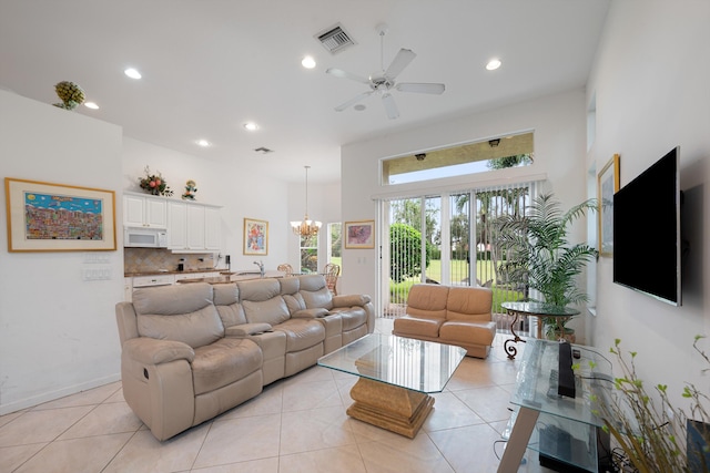 tiled living room featuring ceiling fan with notable chandelier