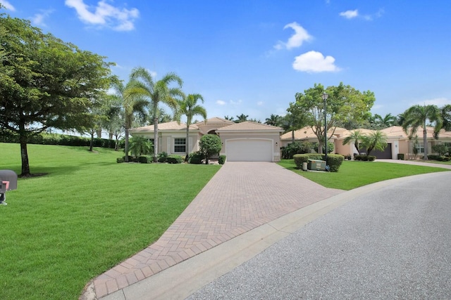 ranch-style house with decorative driveway, a front lawn, and an attached garage