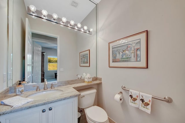 bathroom with vanity, toilet, and lofted ceiling