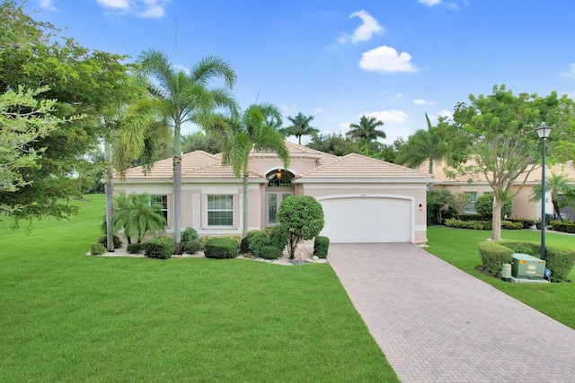 mediterranean / spanish-style house with a garage and a front yard