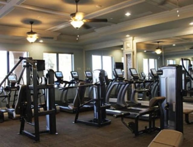 workout area featuring ceiling fan and coffered ceiling