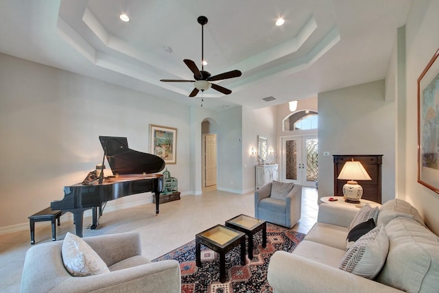 living room with ceiling fan, plenty of natural light, and light tile patterned flooring