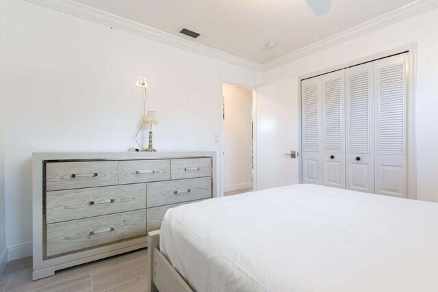 bedroom featuring ornamental molding, a closet, and light hardwood / wood-style floors