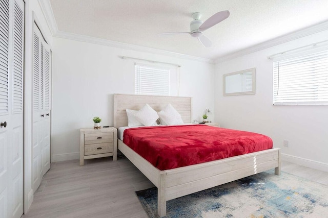 bedroom featuring multiple windows, ceiling fan, light hardwood / wood-style floors, and ornamental molding