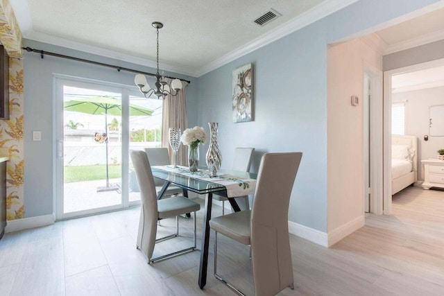 dining room with crown molding, light hardwood / wood-style flooring, a notable chandelier, and a textured ceiling