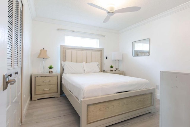 bedroom with a closet, ceiling fan, ornamental molding, and light hardwood / wood-style flooring