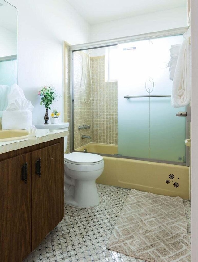 full bathroom featuring enclosed tub / shower combo, toilet, and vanity