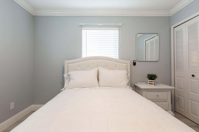 bedroom with crown molding and a closet