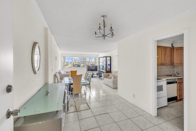 tiled dining area featuring sink, an inviting chandelier, and crown molding