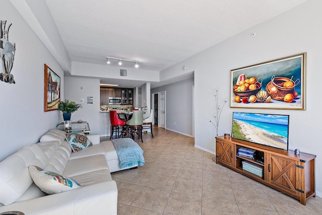 tiled living room featuring a textured ceiling