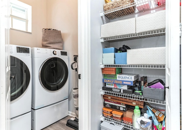 laundry room with washer and dryer and wood-type flooring