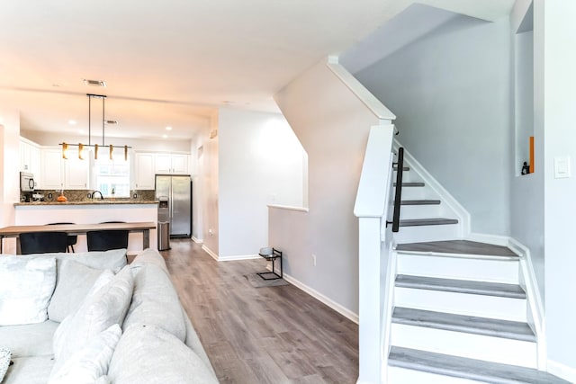 living room with light hardwood / wood-style floors and sink